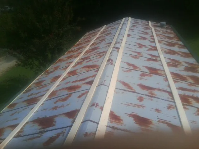 Rusted metal roof panels with new wood purlins before replacement — Storm Damage Roof Repair in Eloy by Roofing Brothers